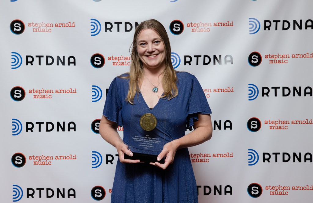 Melissa Sevigny displaying the Murrow Award plaque.